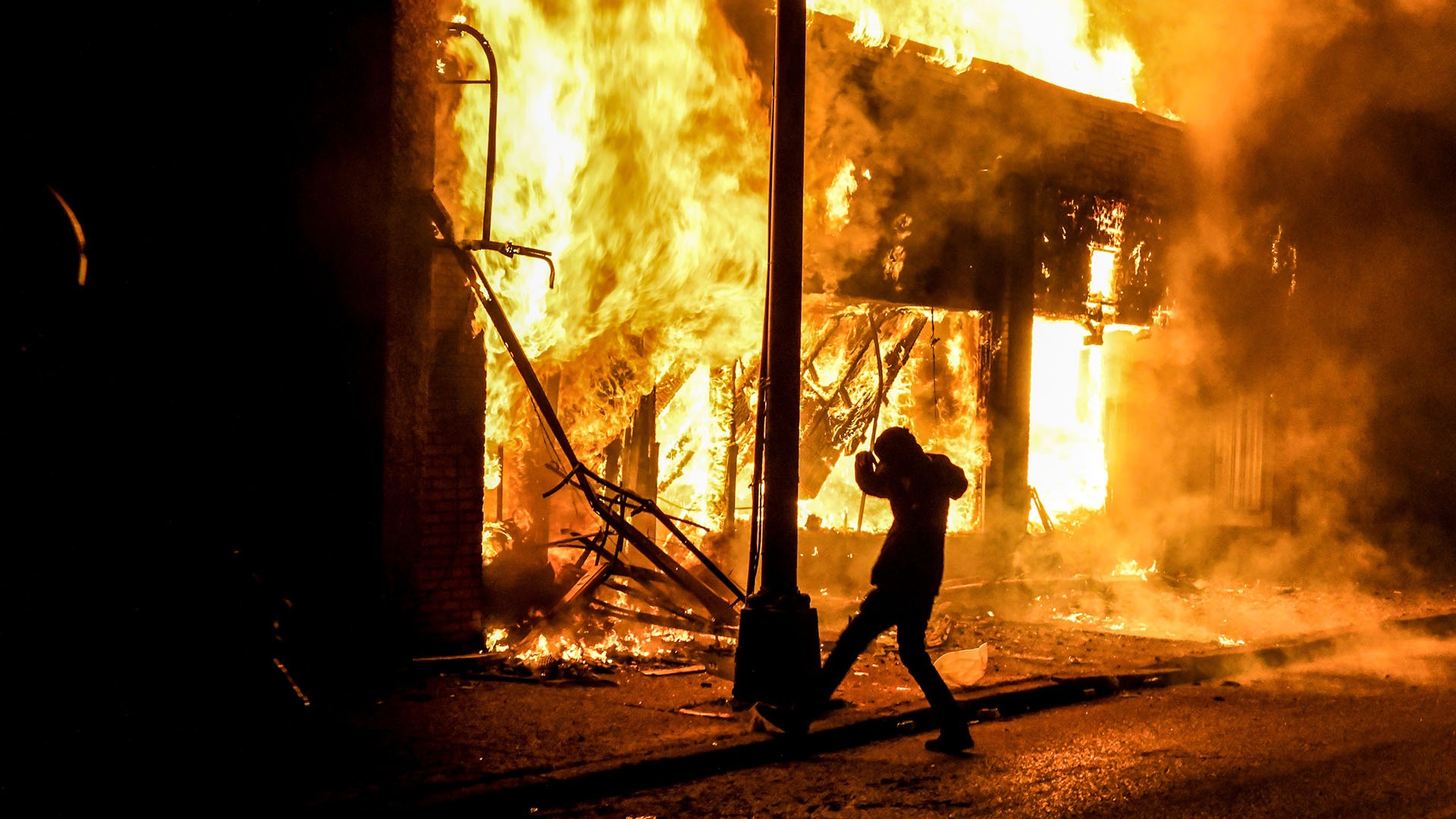 Un manifestante rodeado de fuego en Minneapolis, Minnesota (Chandan KHANNA / AFP)