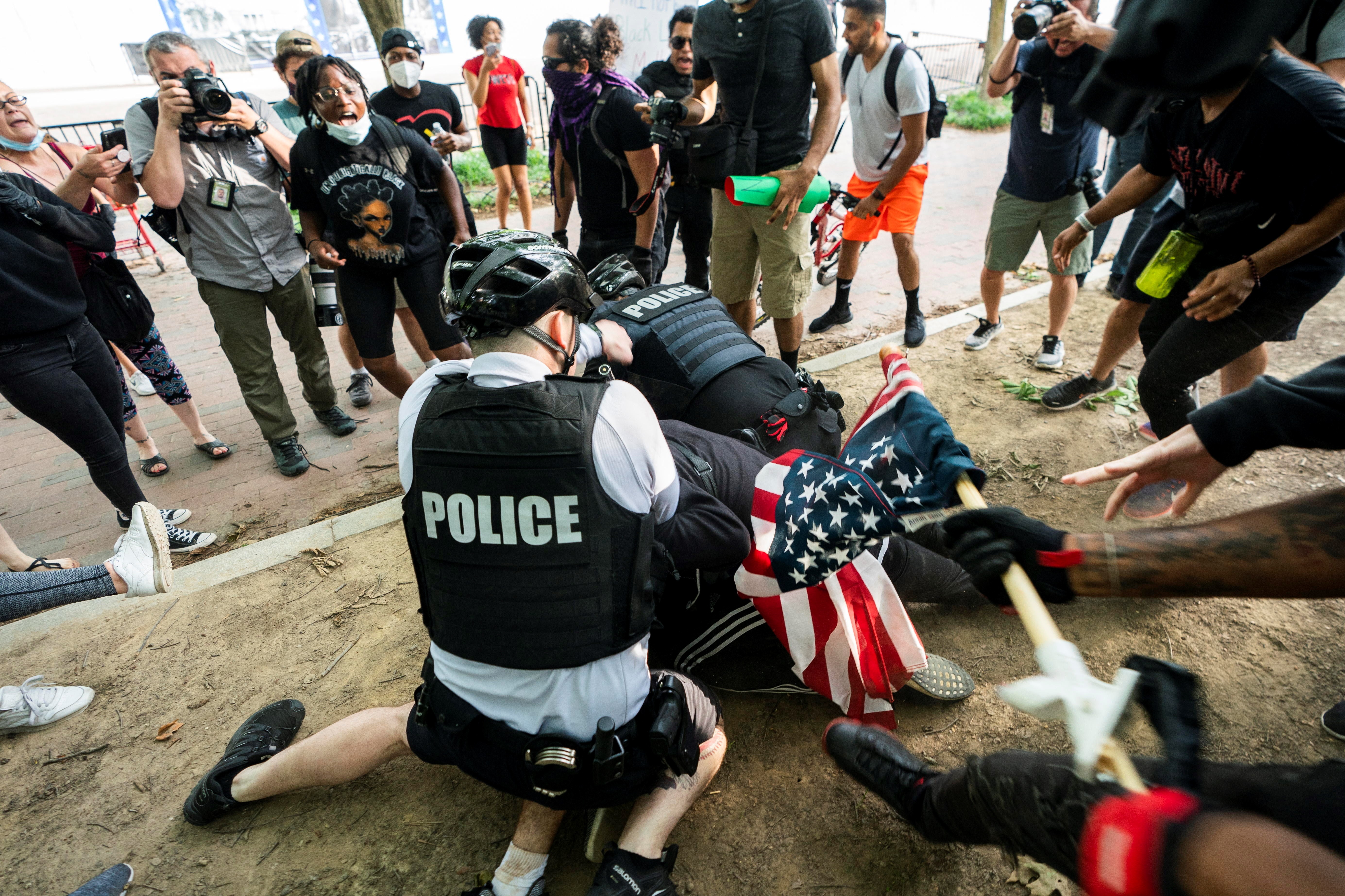 En Washington DC se produjo una manifestación por la tarde de este viernes, donde oficiales de la policía arrestan a un participante que fue reducido contra el piso (EFE/EPA/JIM LO SCALZO) 