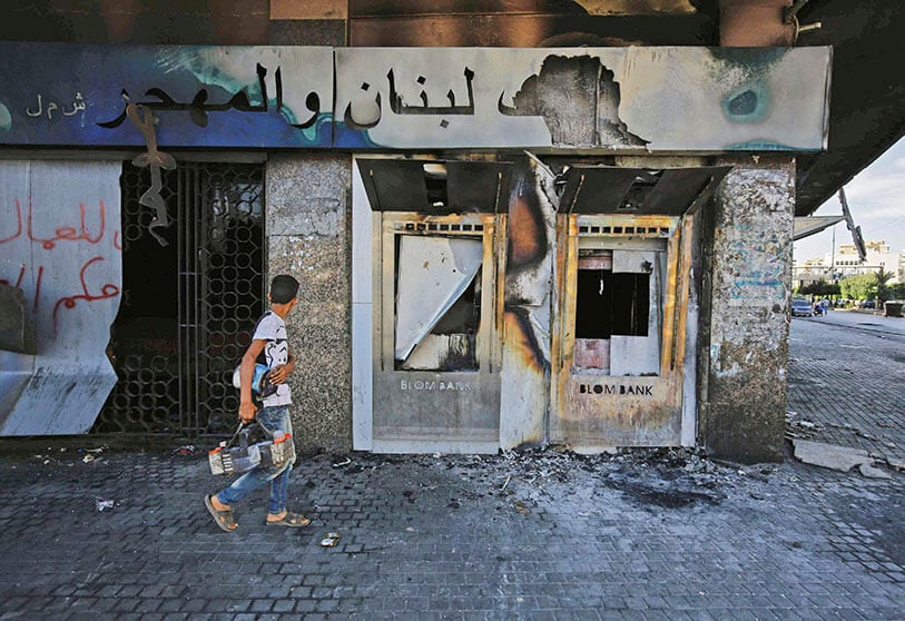 Sucursal quemada de un banco libanés después de que fuera incendiada y vandalizada por los manifestantes anteriormente, en la plaza al-Nour en la ciudad portuaria norteña de Trípoli el 12 de junio de 2020