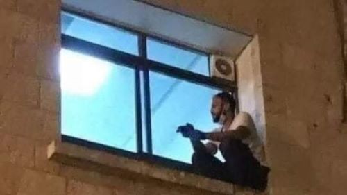 Palestina. Joven palestino escala hasta la ventana del hospital para despedirse de su madre que falleció por coronavirus
