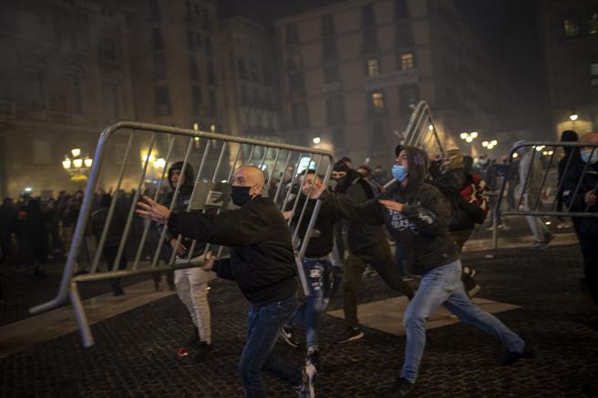 Violencia.Un grupo de manifestantes lanza las vallas de seguridad que había en la plaza Sant Jaume contra los agentes