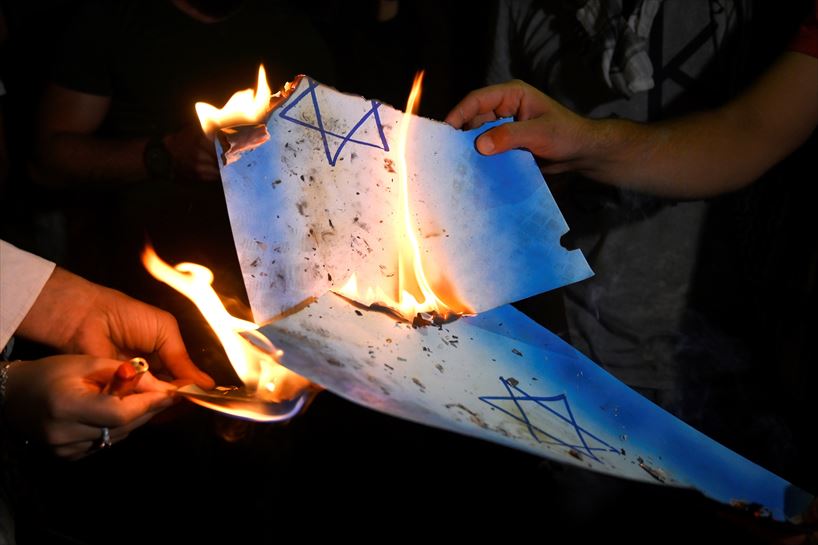 Manifestantes quemando banderas de Israel.