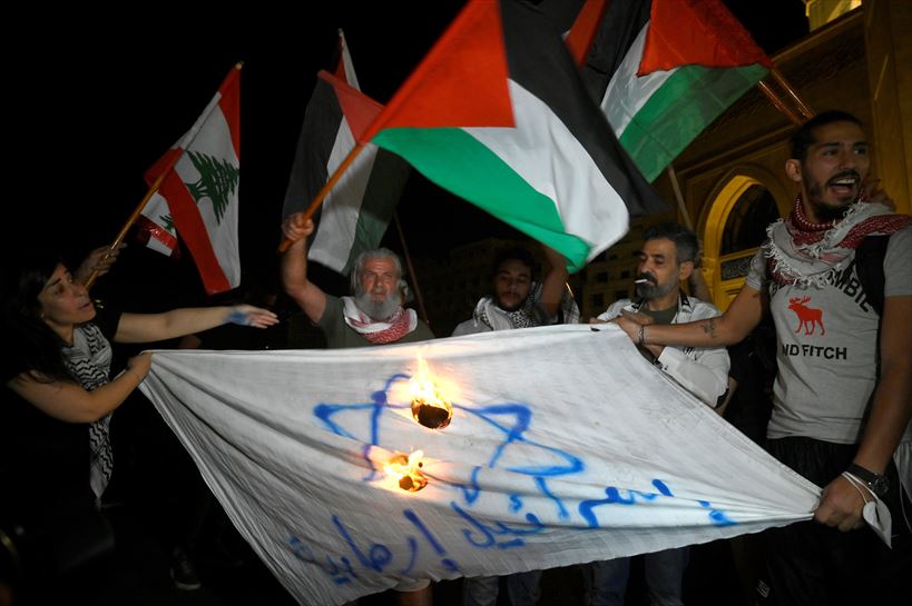 Manifestantes queman una bandera de Israel.