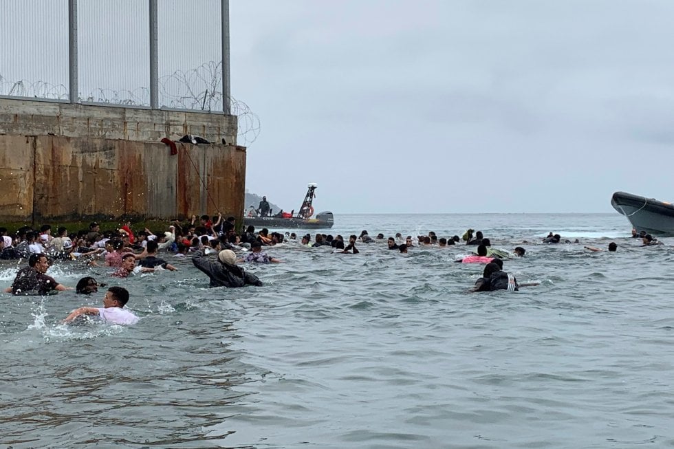 Un grupo de personas tratan de llegar a nado desde la playa de la localidad de Fnideq (Castillejos, Marruecos) hacia uno de los espigones de Ceuta, este martes.