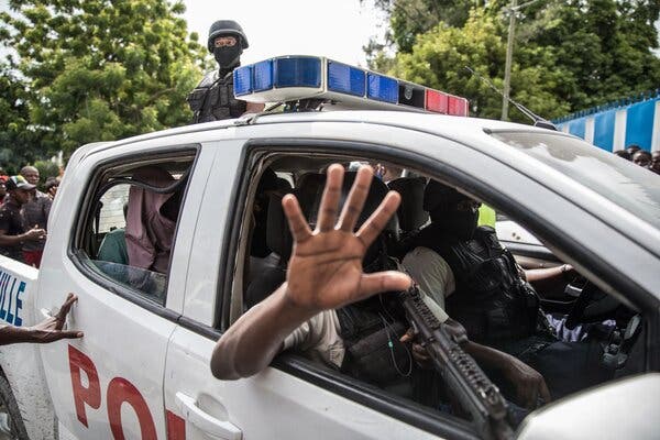 Agentes de policía transportan a dos hombres acusados de participar en el asesinato del presidente Jovenel Moïse