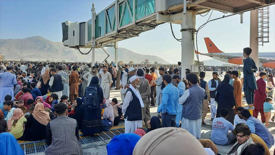 Los afganos se congregan en la pista del aeropuerto de Kabul para huir del país, 16 de agosto de 2021. (Foto: AFP)