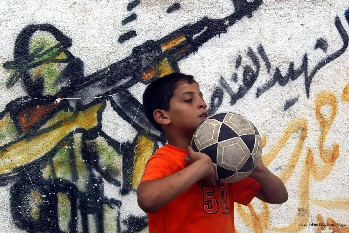 2009_06_25-Palestinian-boy-play-ball-next-to-a-mural-in-Gaza