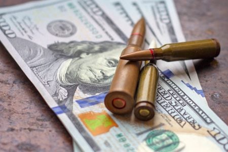 Weapon bullets on American dollars background. Military industry, war, global arms trade and crime concept.